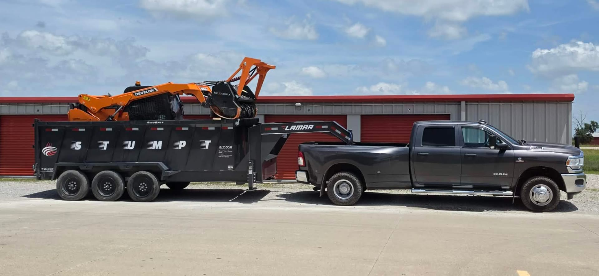 Ram dually towing the STUMPT gooseneck trailer loaded with the Develon and mulcher